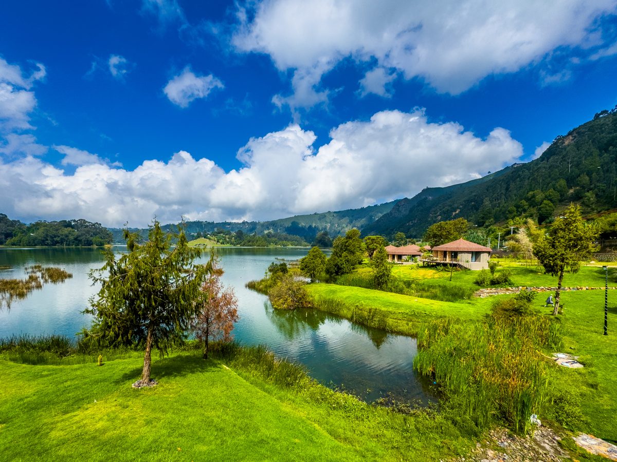 Lakeside lodge grounds surrounded by green highlands